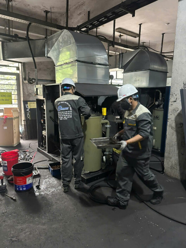 Kỹ thuật viên Việt Nhật đang căn chỉnh khe hở trục vít khi sửa máy nén khí gần nhất