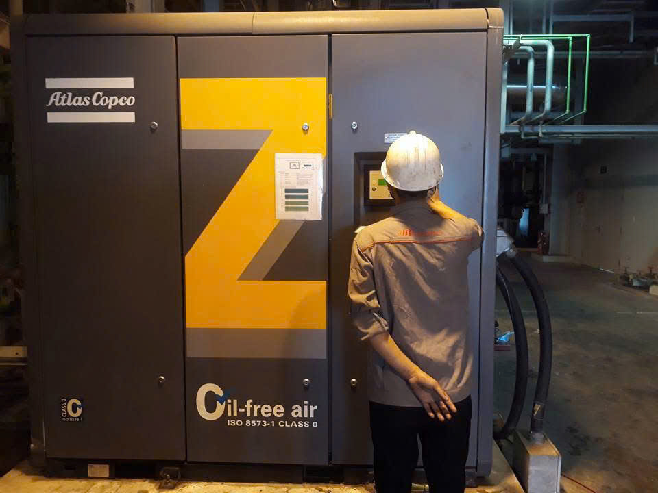 Kỹ thuật viên kiểm tra bộ điều khiển Elektronikon trên máy nén khí Atlas Copco VSD không dầu.