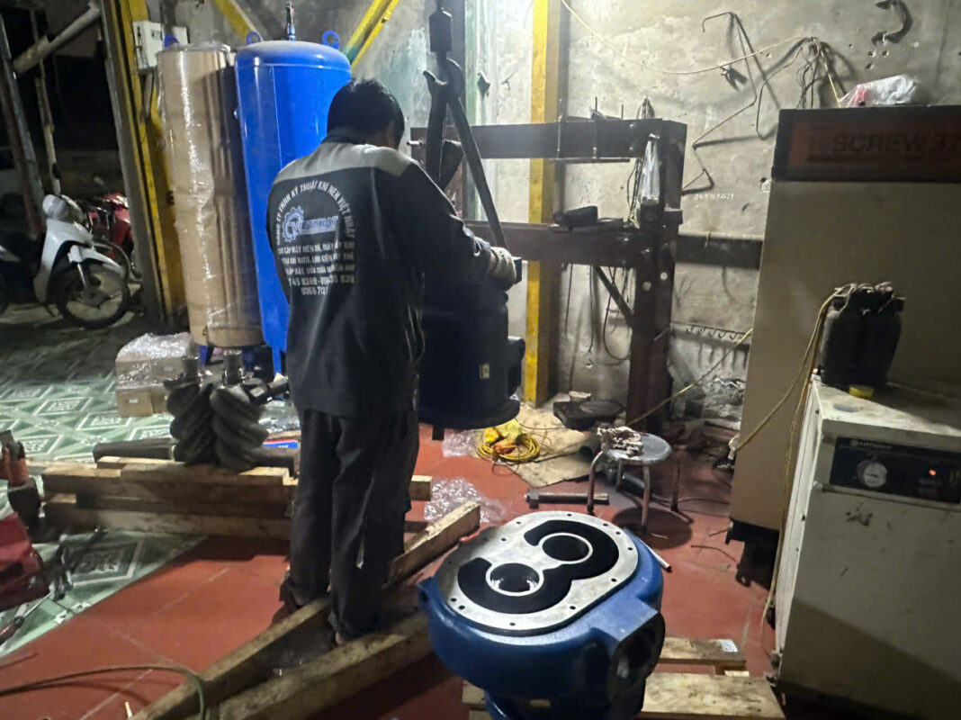 Kỹ thuật viên mặc áo đồng phục đang tập trung lắp ráp cho việc đại tu đầu nén trục vít