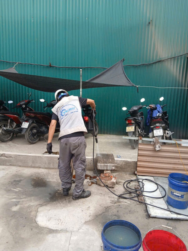 Hình ảnh thực tế quy trình vệ sinh giàn làm mát máy nén khí bị bám dầu bẩn nặng. Kỹ thuật viên Việt Nhật thực hiện xịt rửa chuyên nghiệp để đảm bảo hiệu suất giải nhiệt tối đa cho máy.